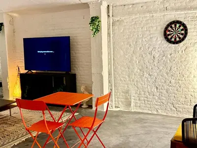 a dining room with a table and two chairs and a tv at Spacious BXL Loft in Brussels