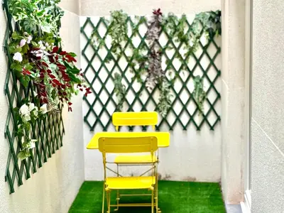 a yellow chair sitting next to a fence with flowers at Spacious BXL Loft in Brussels