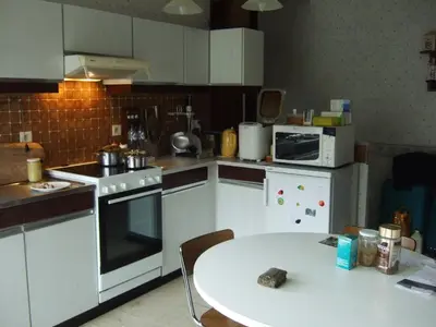 a kitchen with a table and a kitchen with white appliances at Bij het station van Drongen in Ghent