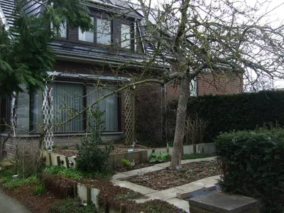 a house with a tree in the front yard at Bij het station van Drongen in Ghent