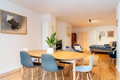 a dining room and living room with a table and chairs at Cosy EU Apartment - Central, Parking, Terrace in Brussels