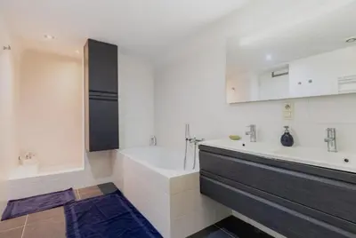 a white bathroom with a tub and a sink at Cosy EU Apartment - Central, Parking, Terrace in Brussels