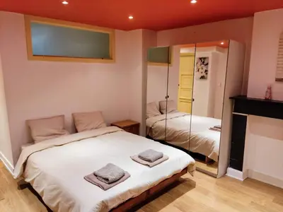 a bedroom with two beds and a mirror at Modern half-basement 1BR near Montgomery & VUB in Brussels