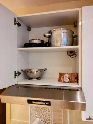 a kitchen with two pots and pans on shelves at Modern half-basement 1BR near Montgomery & VUB in Brussels