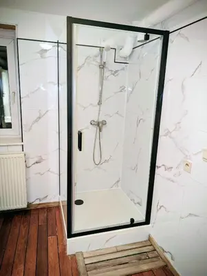 a bathroom with a shower with white marble at Modern half-basement 1BR near Montgomery & VUB in Brussels