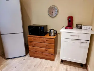 a kitchen with a microwave on a dresser next to a refrigerator at Modern half-basement 1BR near Montgomery & VUB in Brussels