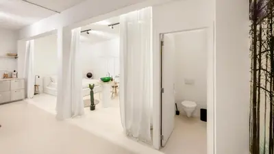 a white bathroom with a shower and a toilet at Modern loft near City Centre, Nomade CasaMia in Antwerp