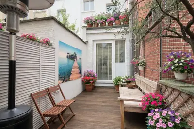 a patio with two chairs and flowers on a building at Modern loft near City Centre, Nomade CasaMia in Antwerp