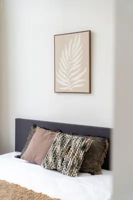 a picture hanging above a bed with a pillow at Spacious 7-Person House in the Heart of Antwerp in Antwerp