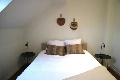 a bedroom with a white bed with two tables at Spacious 7-Person House in the Heart of Antwerp in Antwerp