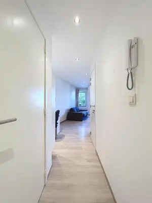 a hallway leading to a living room with a mirror at kazernestraat app 101 in Ghent