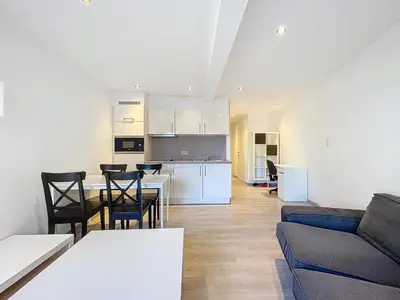 a living room and kitchen with a couch and a table at kazernestraat app 101 in Ghent