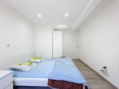 a bedroom with a bed in a white room at kazernestraat app 101 in Ghent
