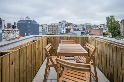 a wooden table and chairs on the roof of a building at Brussels Louise Design residence in Brussels