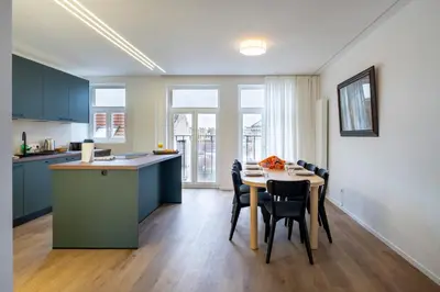 a kitchen and dining room with a table and chairs at Brussels Louise Design residence in Brussels