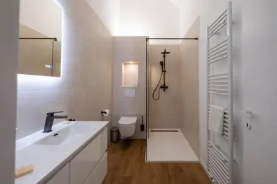 a white bathroom with a sink and a toilet at Brussels Louise Design residence in Brussels