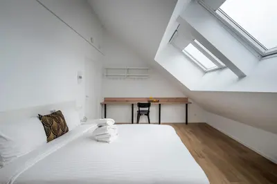 a attic bedroom with a bed and a desk at Brussels Louise Design residence in Brussels