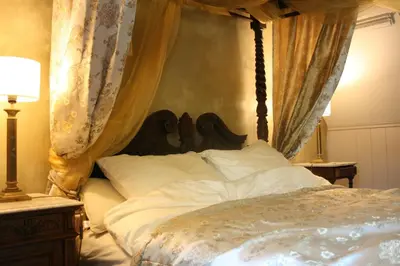 a bedroom with a canopy bed with white pillows at Casa Lucinda in Ghent