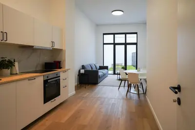 a kitchen and living room with a couch and a table at Appartment St guidon 1 in Brussels