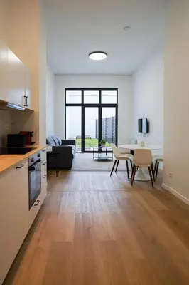 a kitchen and living room with a table and chairs at Appartment St guidon 1 in Brussels