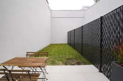 a patio with a table and chairs and grass at Appartment St guidon 1 in Brussels