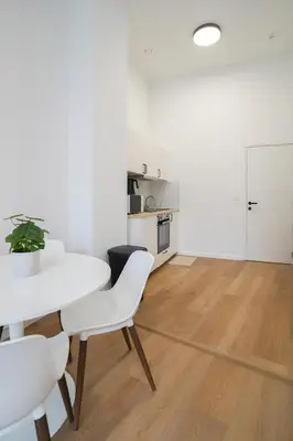 a white dining room with a white table and chairs at Appartment Vaillance 2 in Brussels