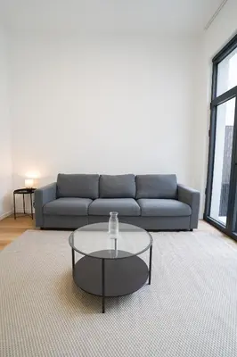 a living room with a couch and a glass coffee table at Appartment Vaillance 2 in Brussels