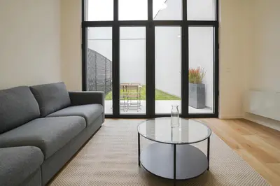 a living room with a couch and a glass table at Appartment Vaillance 2 in Brussels