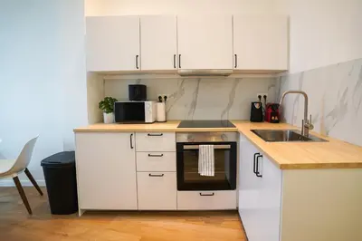 a small kitchen with white cabinets and a sink at Appartment Wayez 3 in Brussels