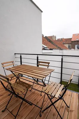 two chairs and a wooden picnic table on a deck at Appartment Wayez 3 in Brussels