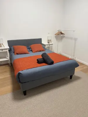 a bed with an orange blanket and two pillows on it at Appartment Astrid 4 in Brussels