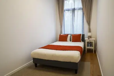 a bedroom with a bed with orange pillows and a window at Appartment Astrid 4 in Brussels