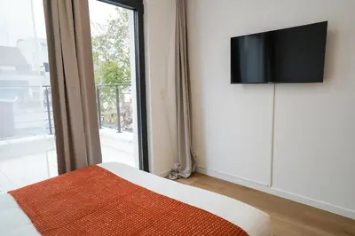 a bedroom with a tv on a wall next to a window at Appartment Janson 5 in Brussels