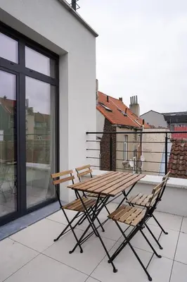 a wooden table and two chairs on a balcony at Appartment Janson 5 in Brussels