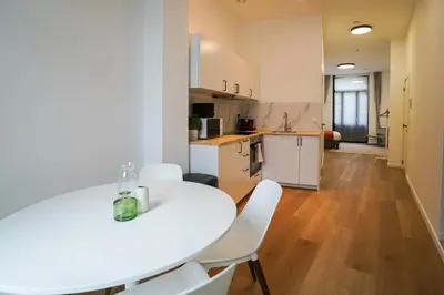 a kitchen and dining room with a white table and chairs at Appartment Janson 5 in Brussels