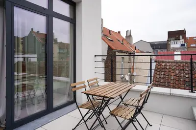 a wooden table and two chairs on a balcony at Appartment Janson 5 in Brussels
