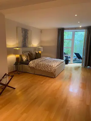 a bedroom with a bed and a wooden floor at Brussels' Premier Parkside Residence in Brussels