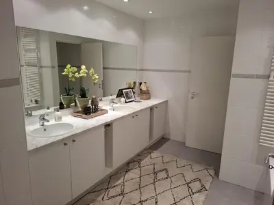 a white bathroom with two sinks and a mirror at Brussels' Premier Parkside Residence in Brussels