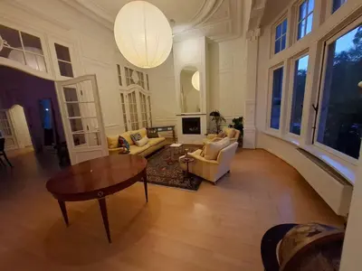 a large living room with a table and chairs at Brussels' Premier Parkside Residence in Brussels