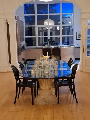 a dining room with a glass table and chairs at Brussels' Premier Parkside Residence in Brussels
