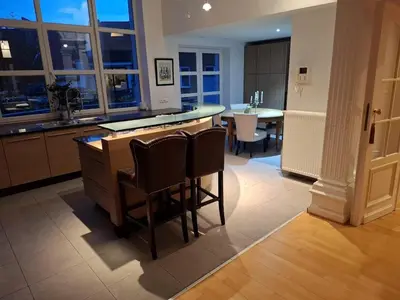 a kitchen with a bar with chairs and a table at Brussels' Premier Parkside Residence in Brussels