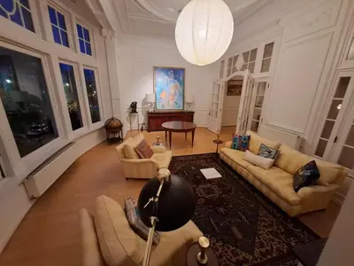 a large living room with couches and a chandelier at Brussels' Premier Parkside Residence in Brussels