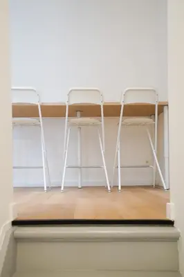 two white chairs and a table in a room at Appartment Douvres 7 in Brussels