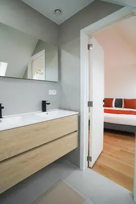 a bathroom with a sink and a mirror and a bed at Appartment Douvres 7 in Brussels