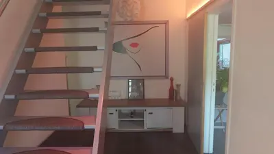 a staircase in a room with a painting on the wall at Beach House in Brasschaat