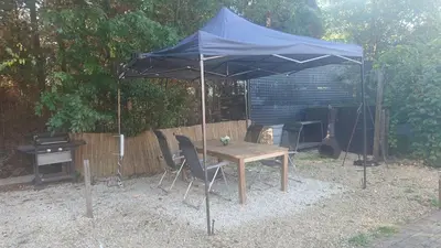 a table and chairs under a blue umbrella at Beach House in Brasschaat