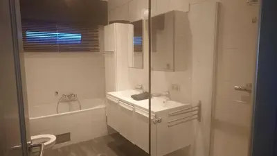 a bathroom with a shower and a sink and a tub at Beach House in Brasschaat