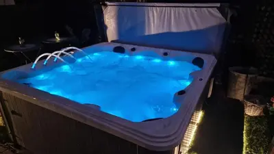 a large hot tub in a backyard at night at Beach House in Brasschaat