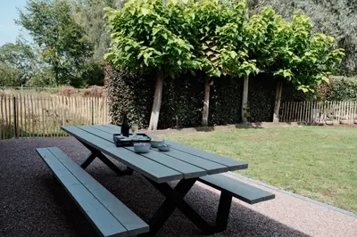 a picnic table and a bench in a garden at Vakantiewoning Welle Weg in Berlare