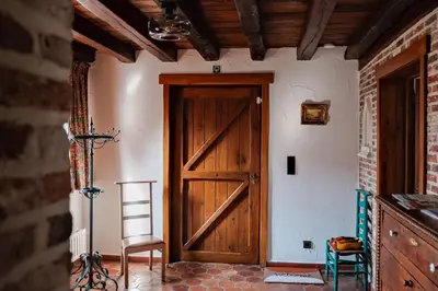 a room with a wooden door and a chair at Vakantiewoning Welle Weg in Berlare